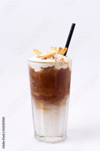Glass of cold coffee drink with whipped cream, syrup and cookies on white background. Beverages, menu concept. Close-up, copy space, layout design, vertical format