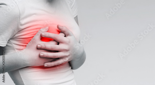 Woman suffering from painful feelings, clutching her boob photo
