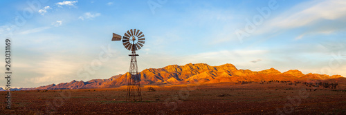 A windmill with the Flinders Ranges behind it in the Australian outback. Flinders Ranges National Park, South Australia, Australia.
