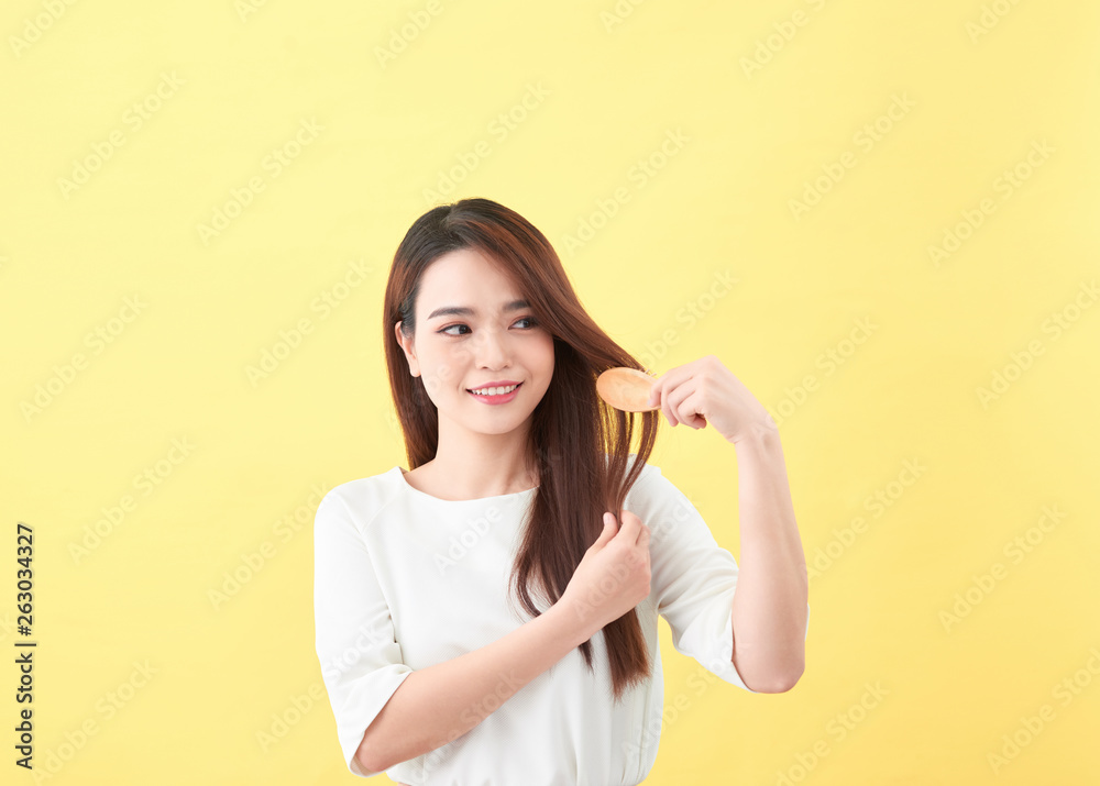 Portrait of beautiful young woman combing her hair and smiling Portrait of beautiful young woman combing her hair and smiling