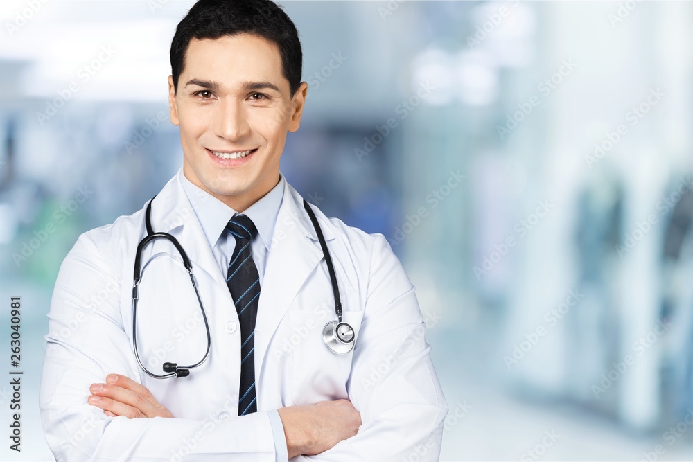Attractive young female doctor with blurred hospital interior on background Attractive young female doctor with blurred hospital interior on background