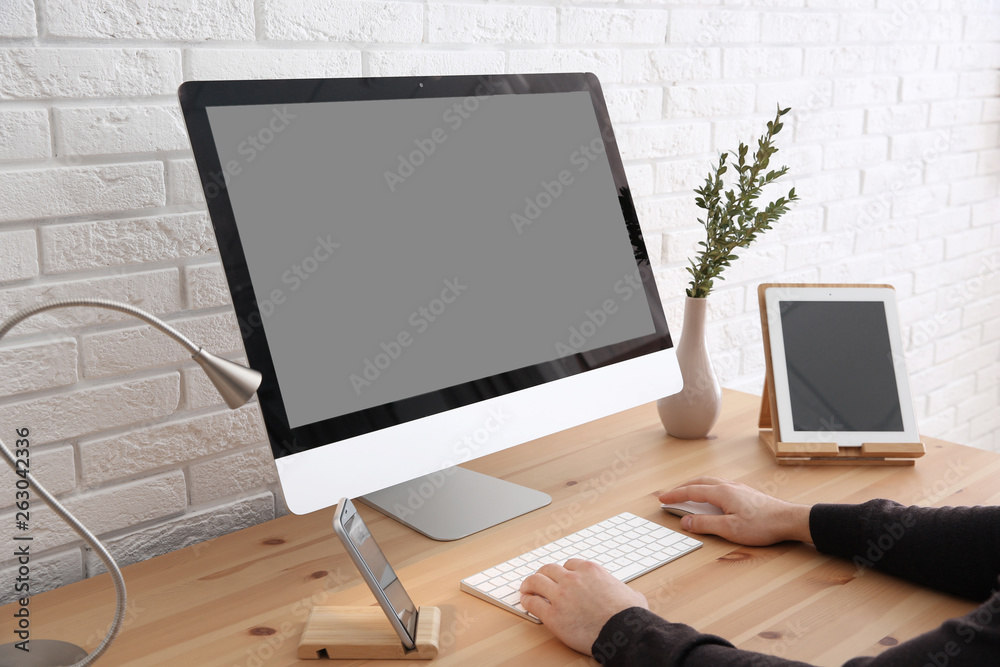 Fototapeta premium Young man using modern computer at table, closeup