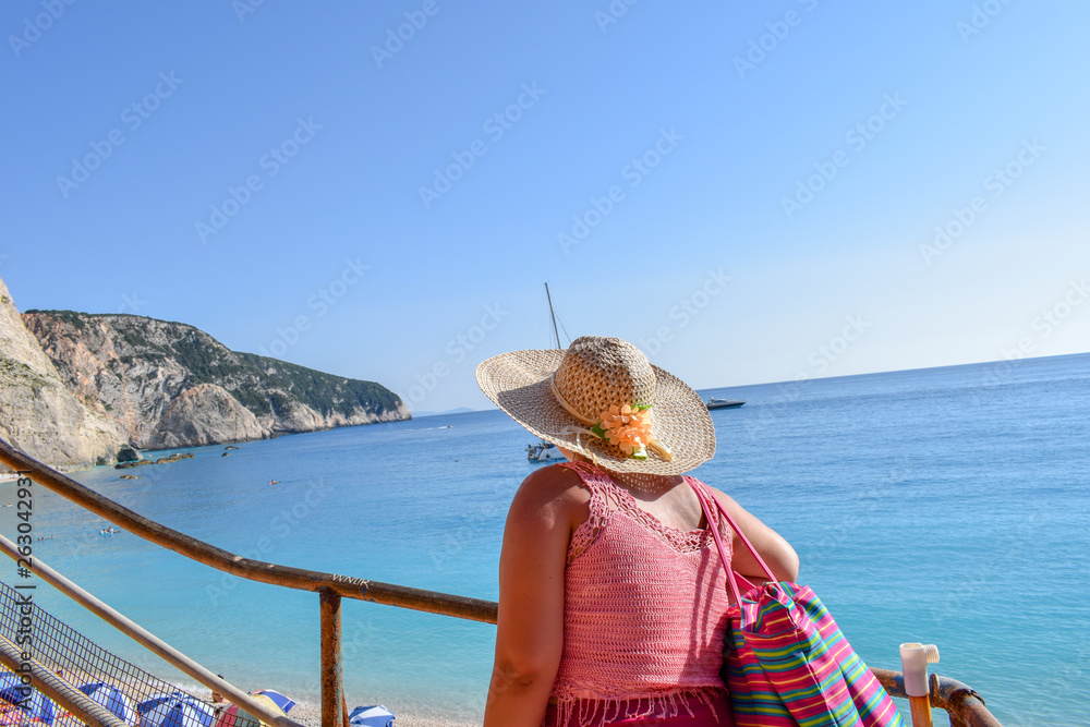Beautiful woman walking on Porto Katskiki beach in Greece