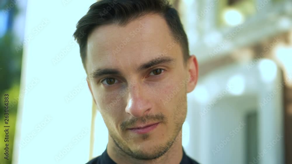 Portrait of handsome young man with straight face . Attractive guy looking at camera standing outdoors. Close up 4K Portrait of handsome young man with straight face . Attractive guy looking at camera standing outdoors. Close up 4K