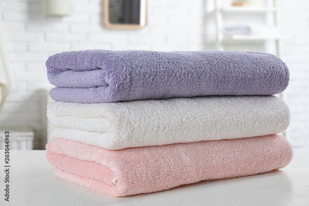 Stack of fresh towels on table in bathroom, closeup Stack of fresh towels on table in bathroom, closeup