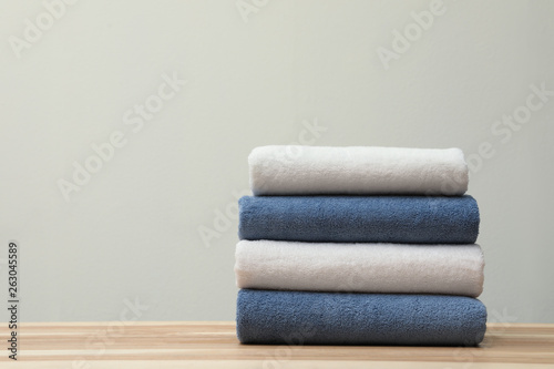 Stack of fresh towels on table. Space for text