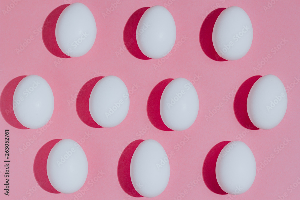 White chicken eggs with empty space, on a pink background. Abstract image White chicken eggs with empty space, on a pink background. Abstract image