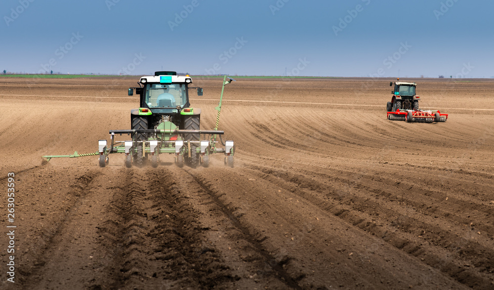 Obraz premium Farmer with tractor seeding sowing crops at agricultural field