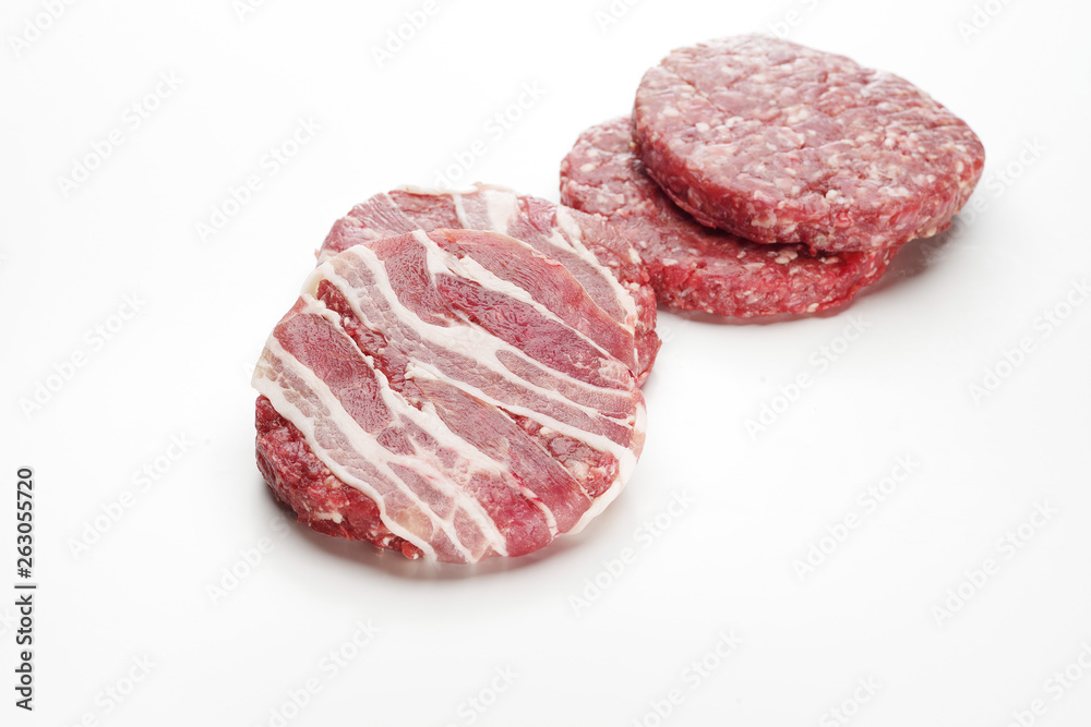 Raw meat patties for burgers on a white background. Raw meat patties for burgers on a white background.