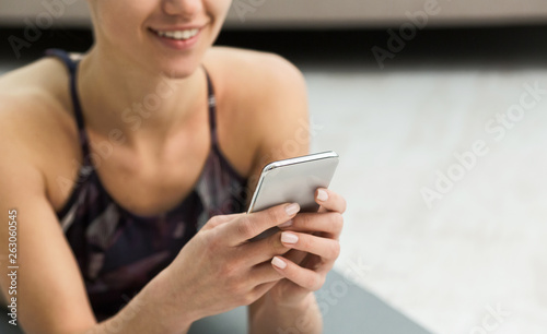 Woman using fitness app on her smartphone after workout