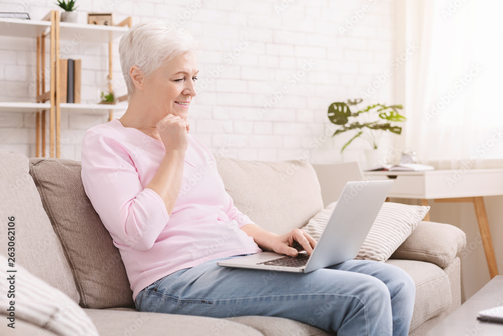 Senior woman playing video games on her laptop