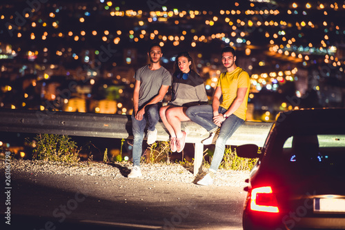 Wallpaper Mural Friends sittinig on road guardrail at night Torontodigital.ca