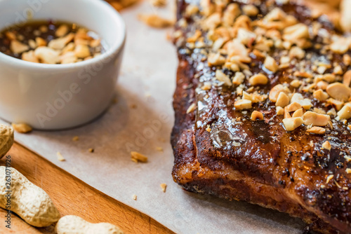 Close up board with pork ribs grilled with BBQ sauce and peanuts
