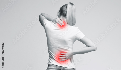 Woman rubbing her painful neck and back