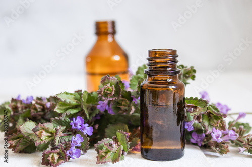 Essential aromatic oil with flowers on wooden background. Selective focus.