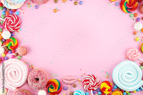 candies with jelly and sugar. colorful array of different childs sweets and treats on pink