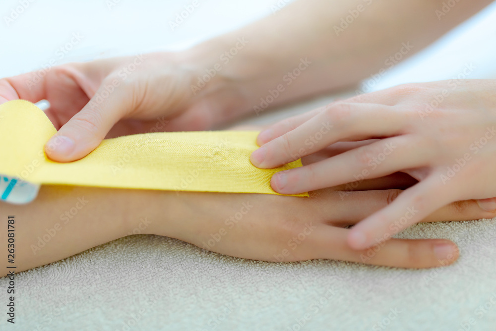 Fototapeta premium Physiotherapeutin klebt ein Tape, Faszien Dehnung