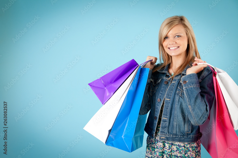 Happy Young Woman Holding Shopping Bags - Isolated on Blue