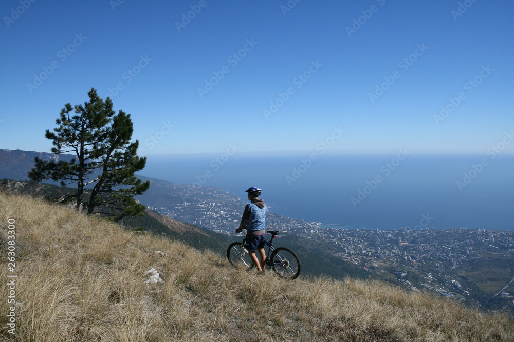 Cyclist admires views of the city of Yalta and the Black sea, Crimea, Russia.