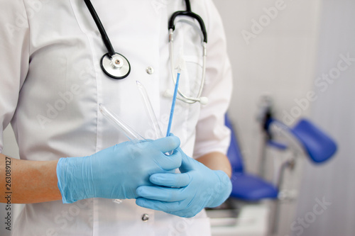 Gynecologist doctor in white uniform in clinic hospital with medicine instrument vaginal speculum, vaginoscope in gloved hands. Gynecological woman health, newborn and pregnancy concept. copyspace.