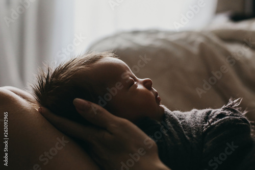 mother's hands holding tenderly her newborn baby girl, close portrait