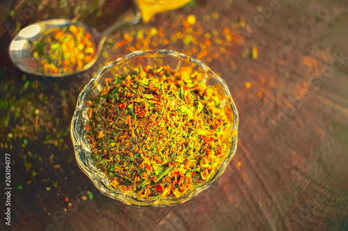 spice mix in glass cup and spoon top view. background with spices.