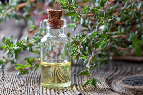 A bottle of thyme essential oil with fresh thyme