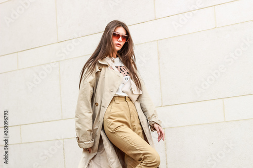 Portrait shooting of a stylish girl. Beige shades. Trends of spring and summer 2019. Pants of cork.Trench cloak, a wide jacket.