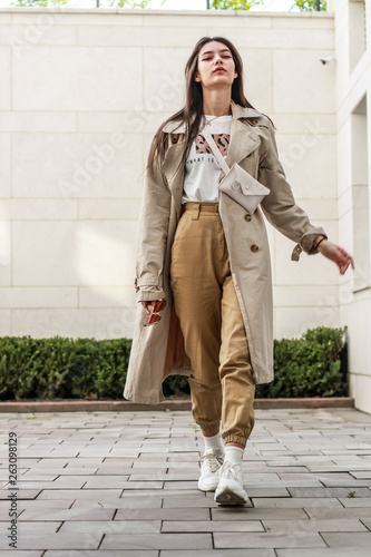 Portrait shooting of a stylish girl. Beige shades. Trends of spring and summer 2019. Pants of cork.Trench cloak, a wide jacket.