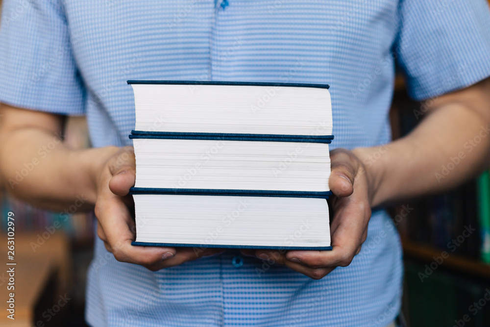 Male hands holding a stack of books. Male hands holding a stack of books.