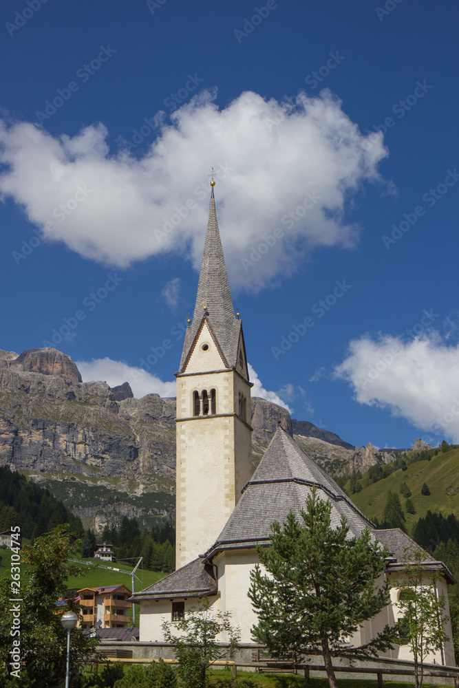 View of Church surrauded by mountains in Arabba village, Dolomites Alps, Italy View of Church surrauded by mountains in Arabba village, Dolomites Alps, Italy