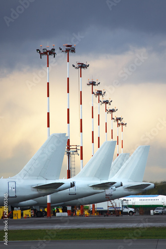 Canvas Print Aircraft tails parked at airport apron against a cloudy sky.