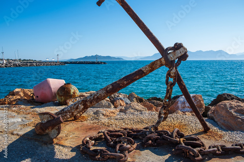 Rusty anchor on the shore at Aegina harbour in Greece