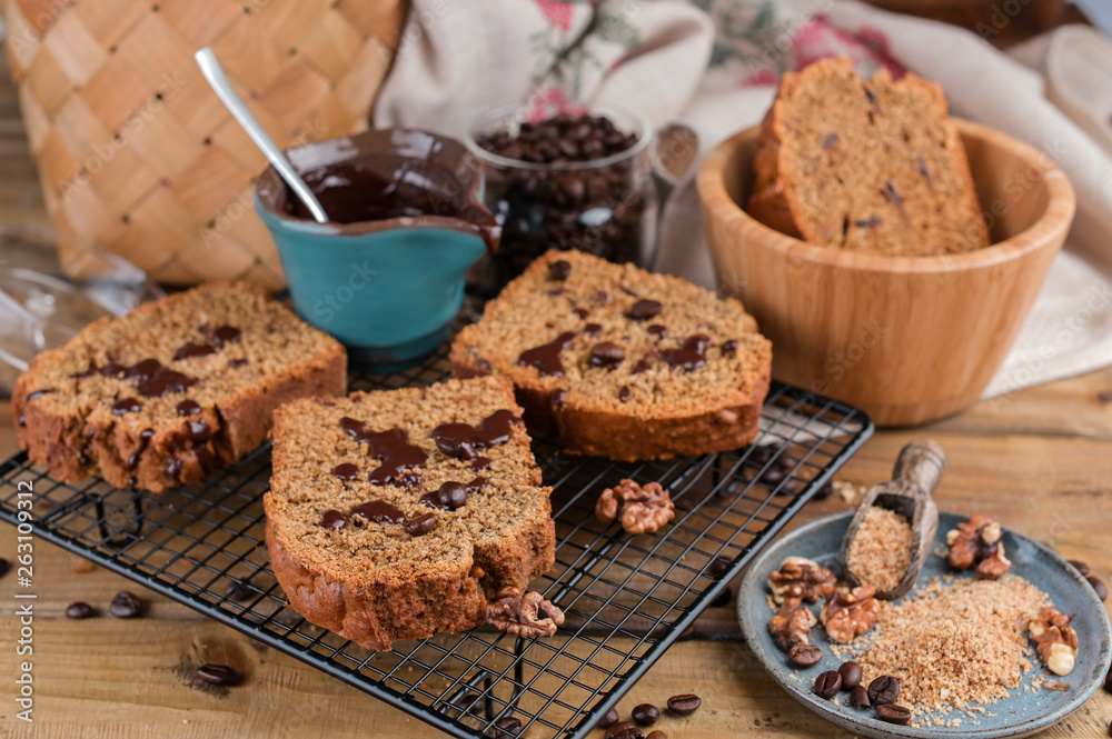 Fototapeta premium Cake with cocoa and chocolate on a wooden table. Sweet homemade pastries for breakfast. Rustic style photo.