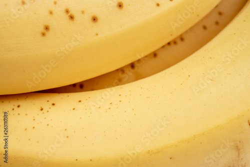 An extreme close-up or macro view of the over-ripe yellow skin of an fresh organic banana fruit.