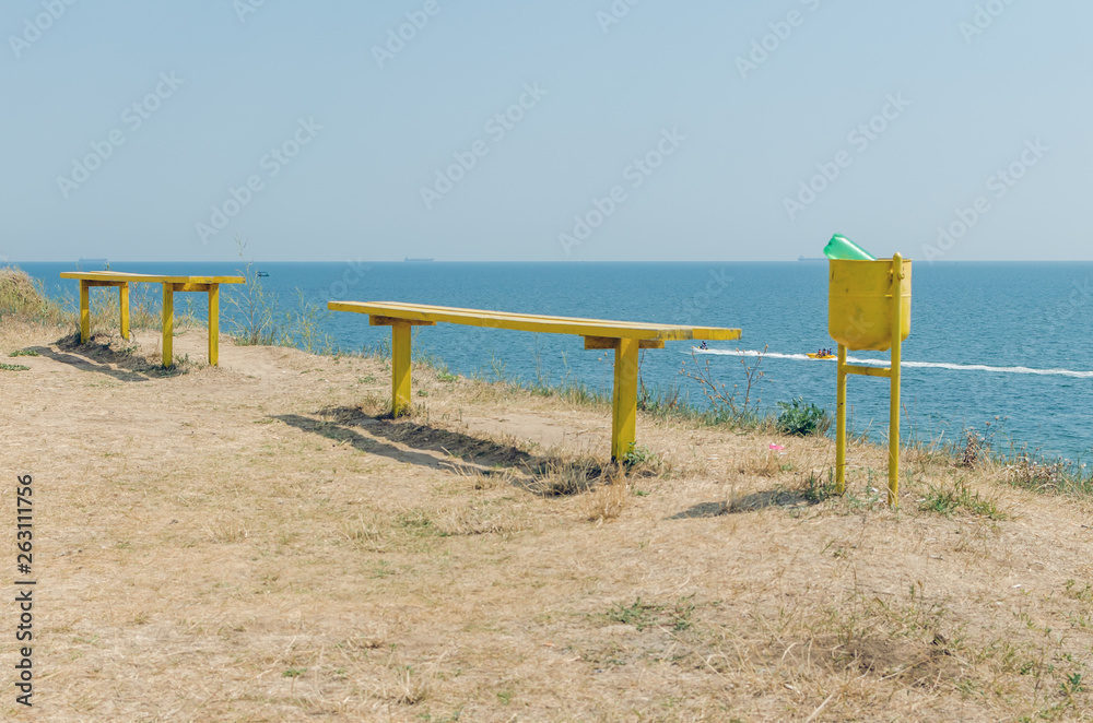 An old wooden bench on a cliff over the sea An old wooden bench on a cliff over the sea