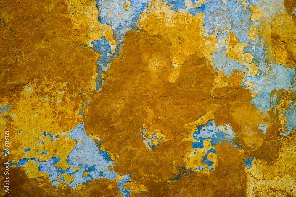 Colorful structure of old shabby wall painted with blue, yellow and brown paint, abstract background