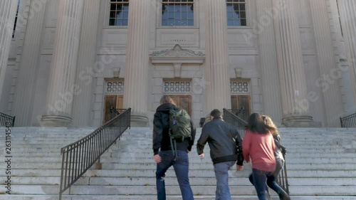 Four college students walking up stairs to a library at a public university photo