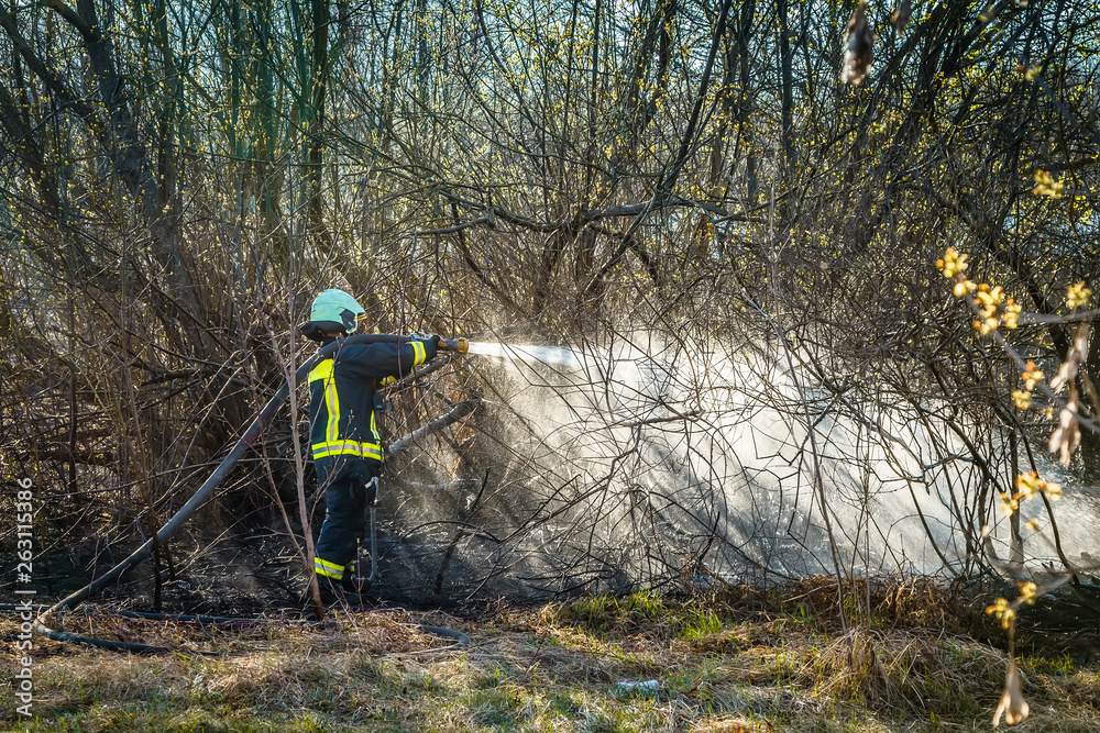 Firefighters work. Burning grass field in the spring Firefighters work. Burning grass field in the spring