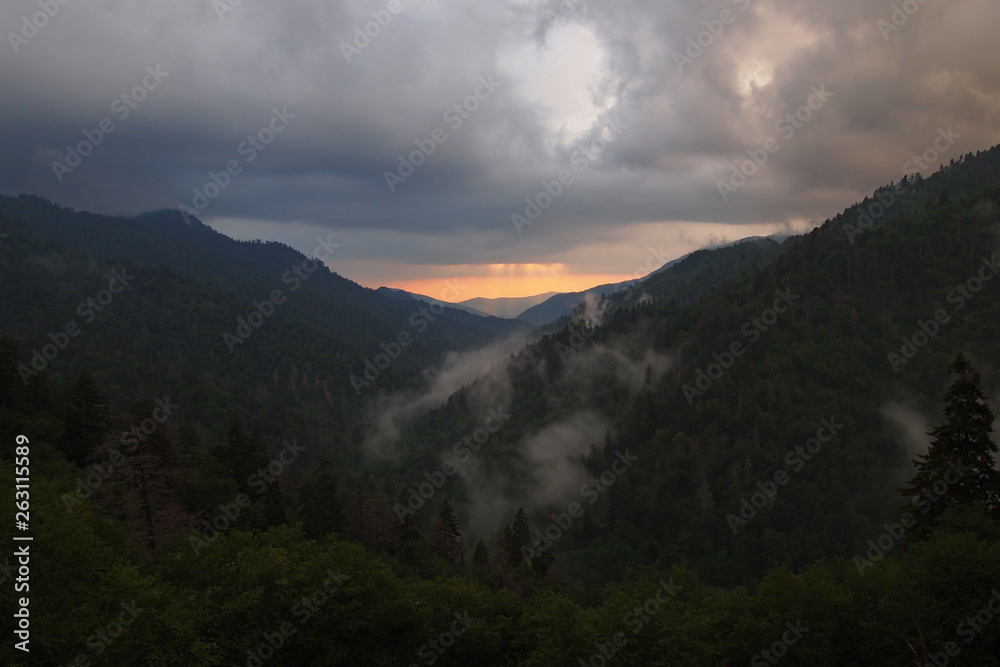 Sunset behind layered mountains under a dramatic cloudscape in the Great Smoky Mountains National Park, Tennessee, in early summer. Sunset behind layered mountains under a dramatic cloudscape in the Great Smoky Mountains National Park, Tennessee, in early summer.