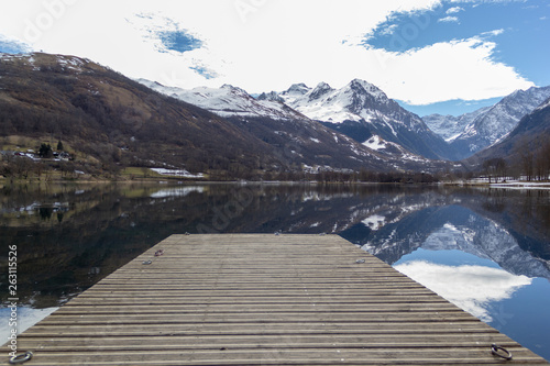 Dock precipitating toward the lake reflection of the mountains