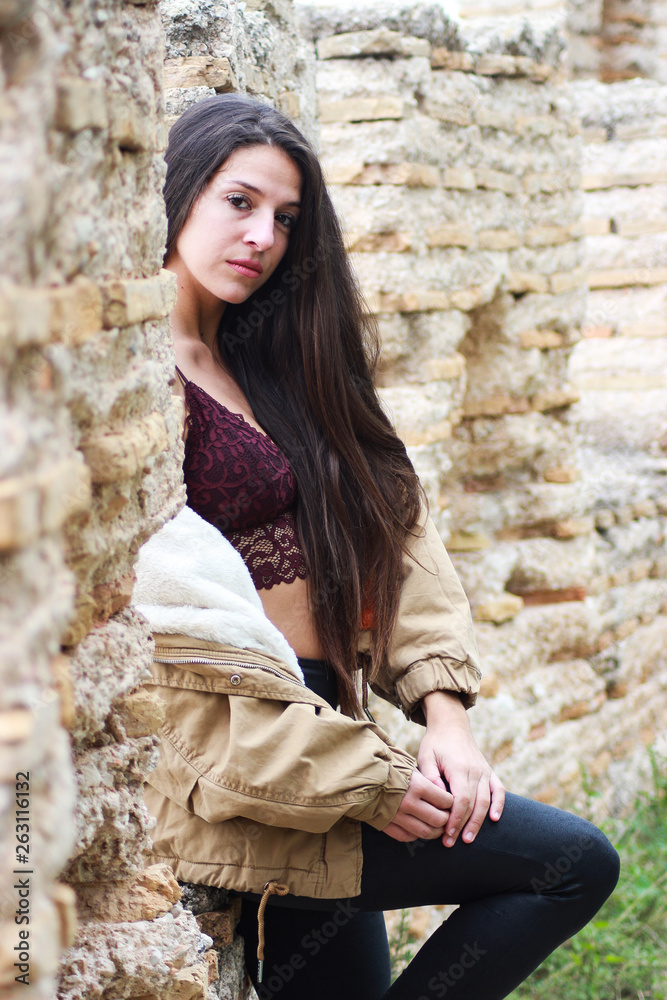 Beautiful young sad woman in black leather jacket in ruins of castle. Fashion Beautiful young sad woman in black leather jacket in ruins of castle. Fashion