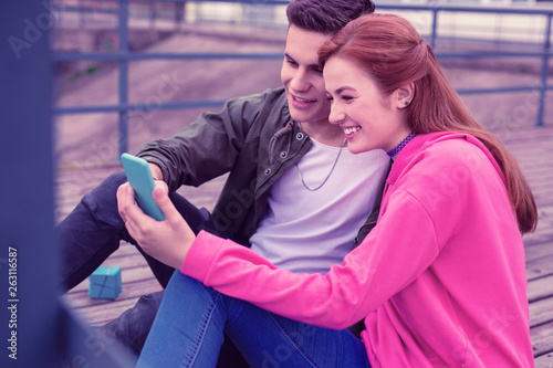 Cheerful good-looking young couple making selfie together