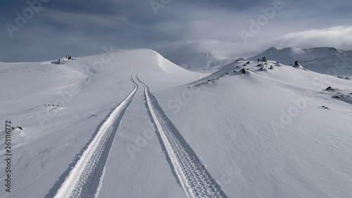 фотографія Superjeep driving on snow creating tracks in Iceland winter in landmannalaugar