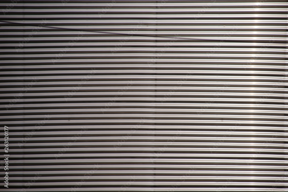 Das Detail der Oberfläche einer glänzenden Wellblechfassade im Sonnenlicht. Das Detail der Oberfläche einer glänzenden Wellblechfassade im Sonnenlicht.