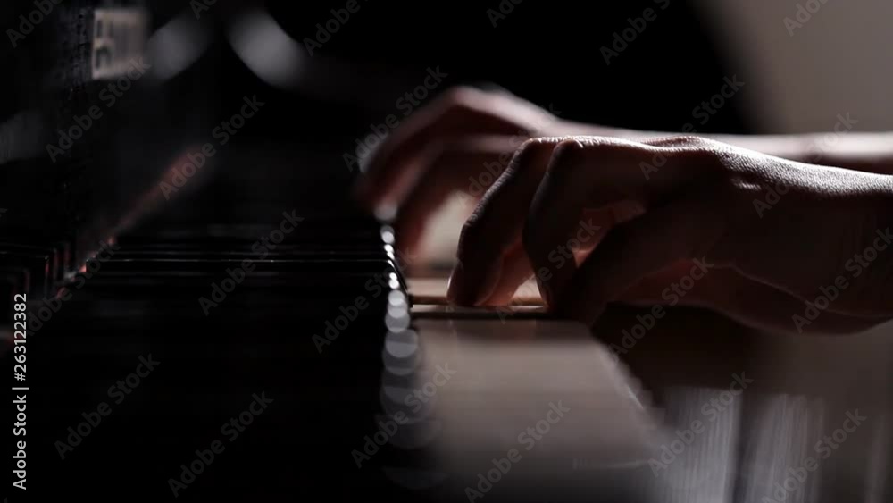 Closeup of the hands of a girl playing the piano instrument keyboard musician. Pianist sound concert