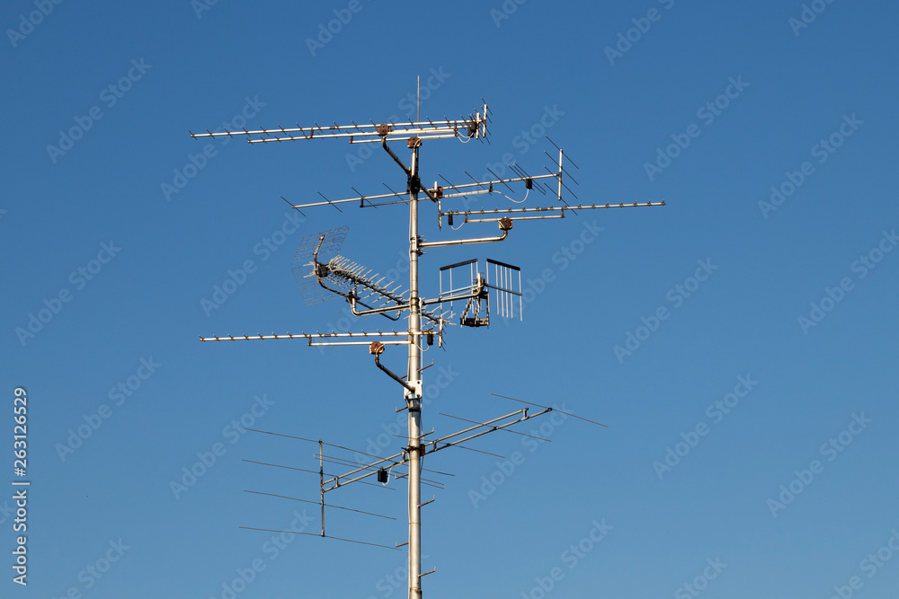 Televisions antennas with blue sky background Televisions antennas with blue sky background