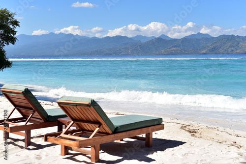 Fototapeta Naklejka Na Ścianę i Meble -  Sun loungers or deckchairs on a sandy beach with ocean view, Gili Trawangan Island, Indonesia