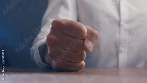 Angry boss beats his fist on the table. Threat of violence. Boss shows aggression.