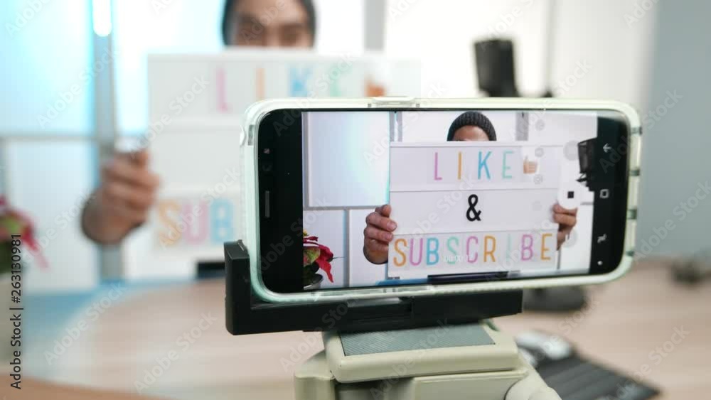 vlogger filming a video of himself asking to the viewers to like and subscribe to his channel on social media. vlogger filming a video of himself asking to the viewers to like and subscribe to his channel on social media.